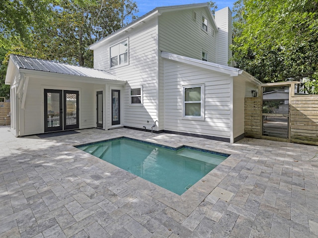 rear view of property with a patio area, an outdoor structure, and french doors