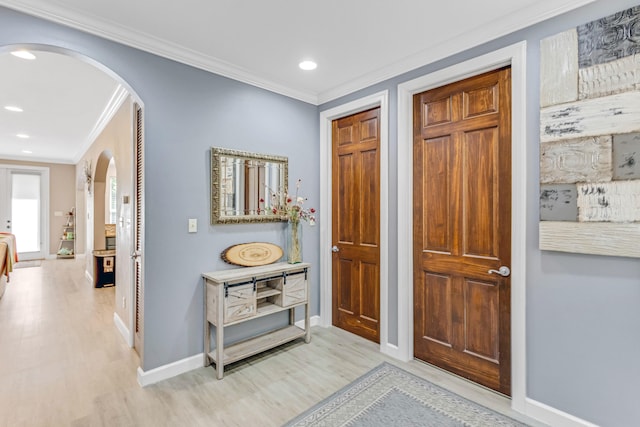 corridor with light hardwood / wood-style floors and crown molding