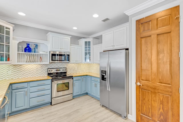 kitchen with crown molding, tasteful backsplash, appliances with stainless steel finishes, light hardwood / wood-style floors, and white cabinets