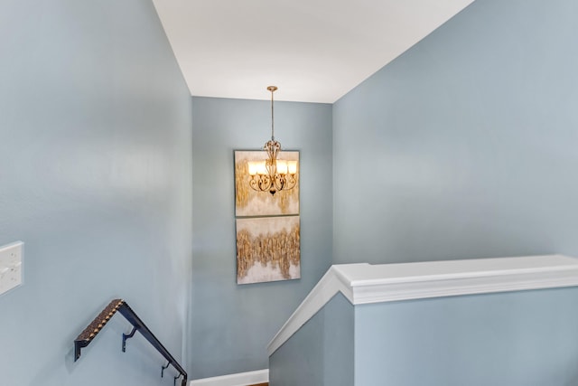 staircase with a notable chandelier