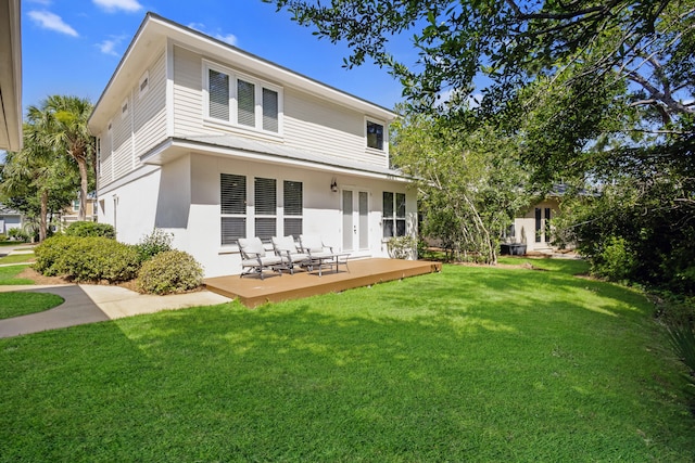 back of property with a wooden deck, a yard, and french doors