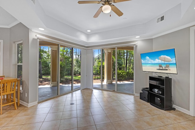 living room with ceiling fan, light tile patterned flooring, crown molding, and a tray ceiling