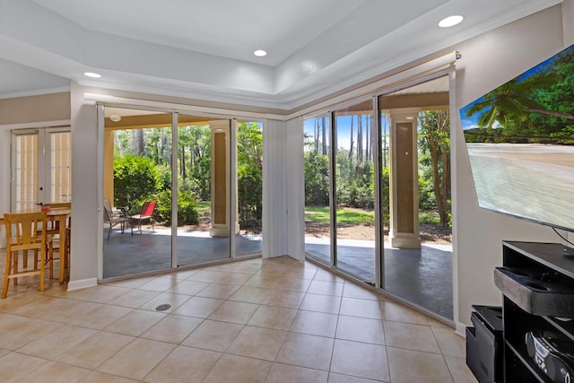 doorway to outside featuring light tile patterned floors, ornamental molding, and a wealth of natural light