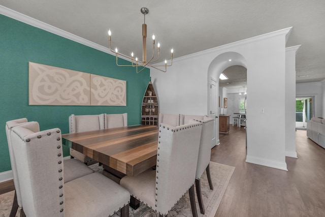 dining room with a chandelier, hardwood / wood-style flooring, and crown molding