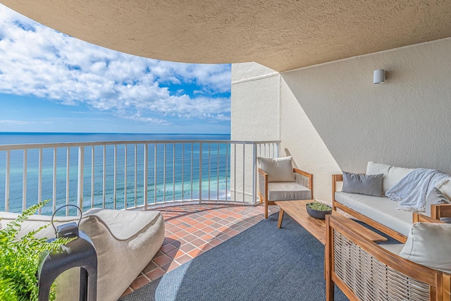 balcony with outdoor lounge area and a water view