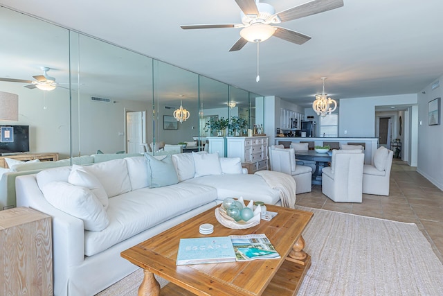 living room featuring ceiling fan with notable chandelier and light tile patterned floors