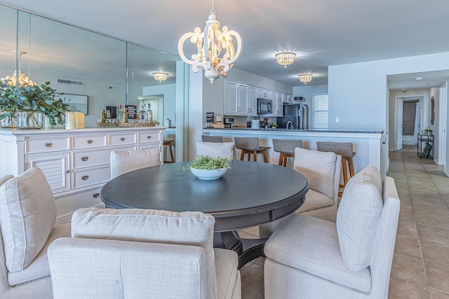 dining space with light tile patterned floors and an inviting chandelier