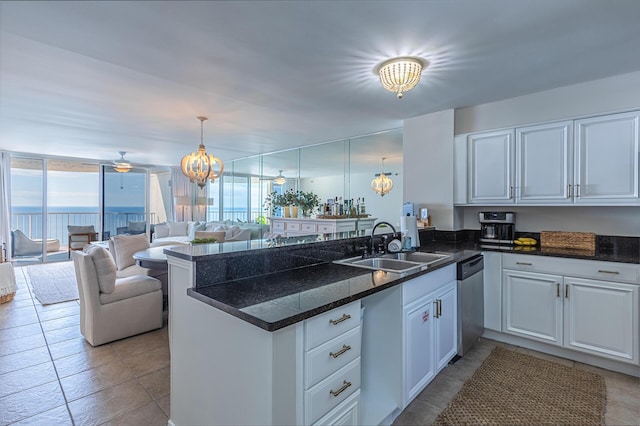 kitchen featuring kitchen peninsula, sink, pendant lighting, a water view, and white cabinetry