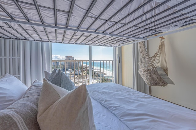 bedroom with a water view and a wall of windows