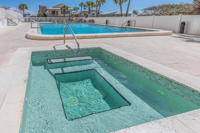 view of pool featuring a community hot tub and a patio