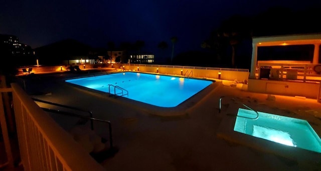 pool at twilight featuring a patio