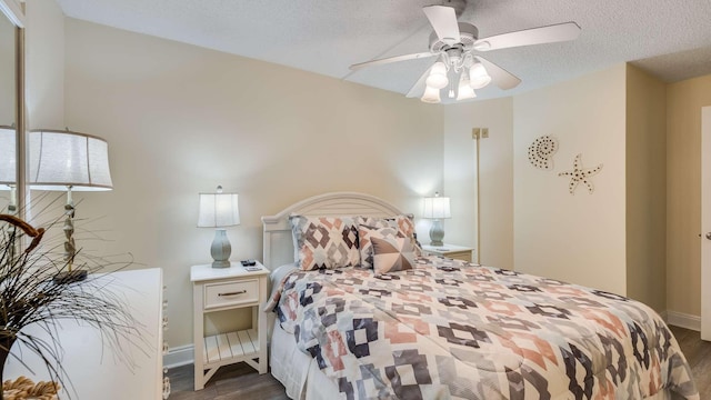 bedroom with ceiling fan, dark hardwood / wood-style floors, and a textured ceiling