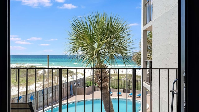 balcony featuring a water view and a beach view