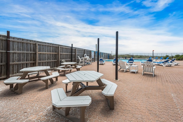 view of home's community with a pool, a patio, and a water view