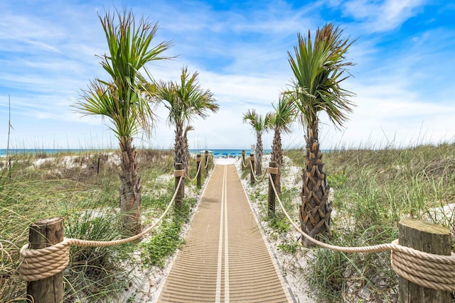 view of property's community featuring a water view and a beach view