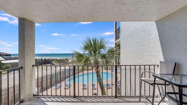 balcony featuring a water view and a beach view