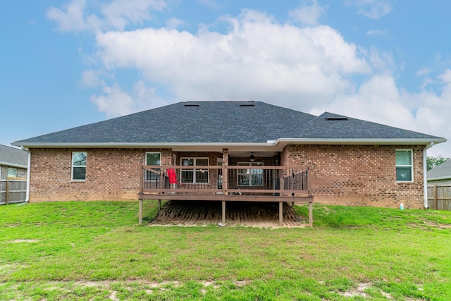 rear view of house with a yard and a wooden deck