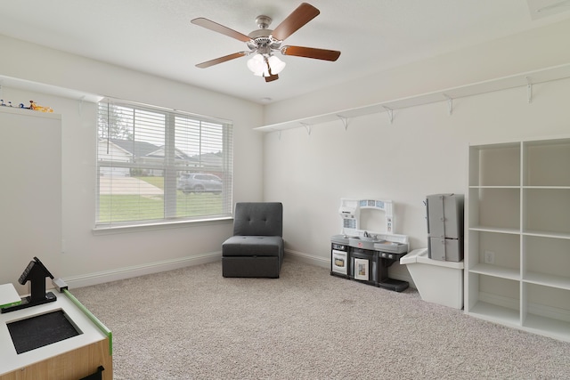 living area featuring carpet flooring and ceiling fan