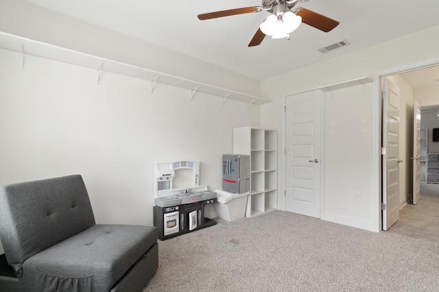 living area featuring ceiling fan and carpet