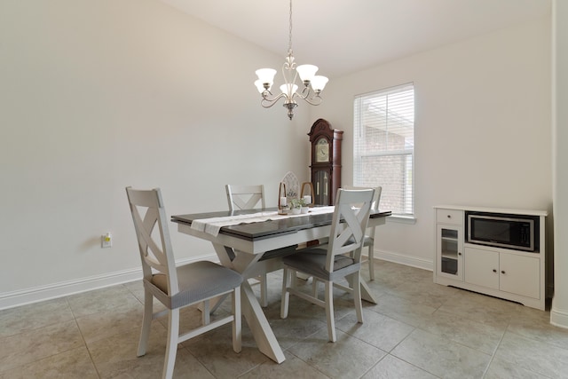 tiled dining room with a chandelier