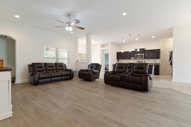 living room with ceiling fan and light hardwood / wood-style flooring