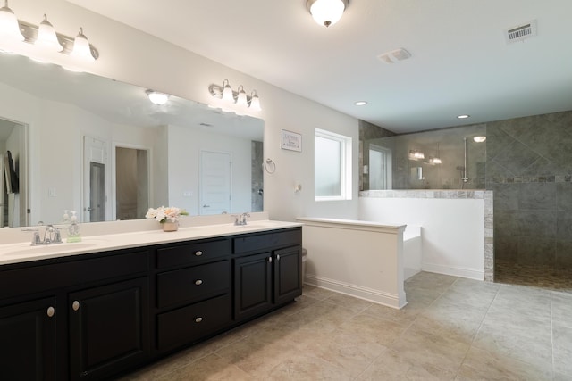 bathroom with tiled shower and vanity