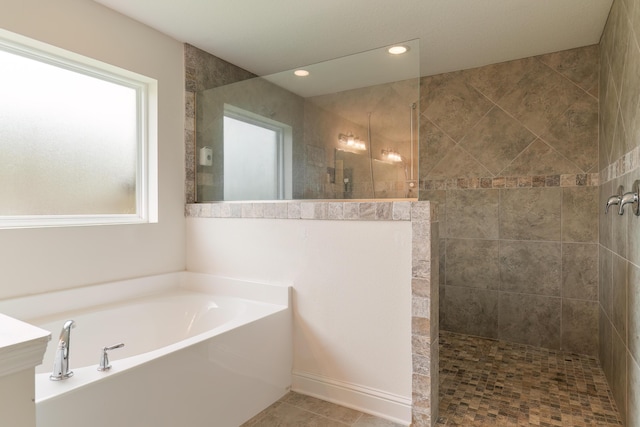 bathroom with independent shower and bath and tile patterned floors