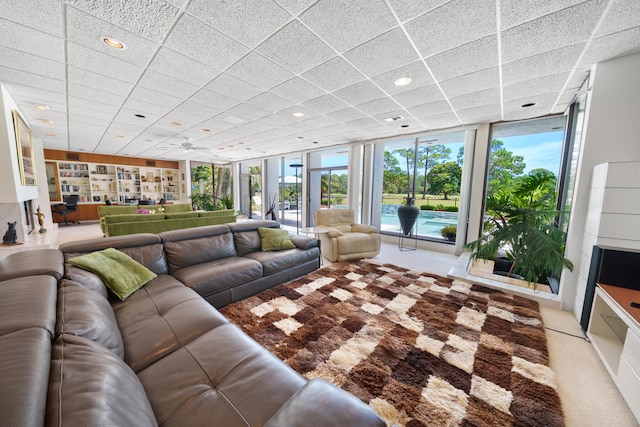 unfurnished living room featuring a paneled ceiling, expansive windows, a healthy amount of sunlight, and light carpet