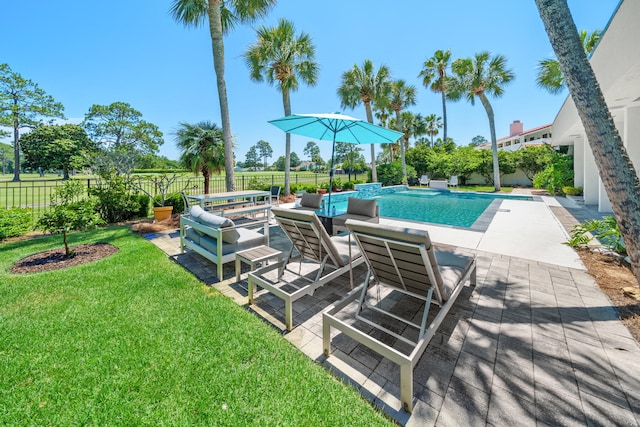 view of pool with an outdoor living space, a yard, and a patio