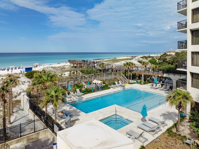 view of pool with a water view, a patio, and a beach view