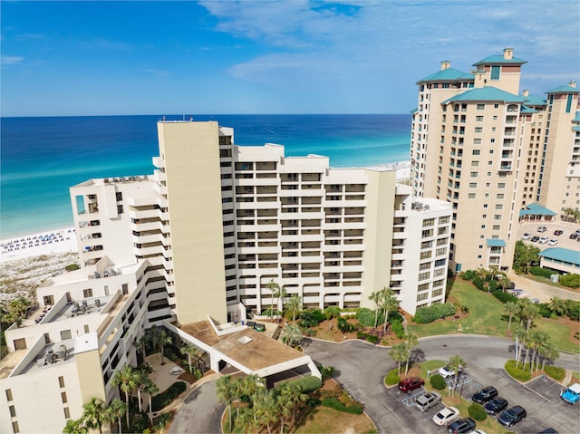 view of building exterior with a water view and a beach view