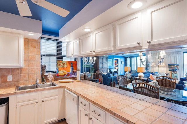 kitchen featuring white dishwasher, tile counters, and white cabinets