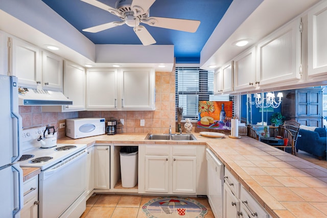 kitchen featuring ceiling fan with notable chandelier, white appliances, white cabinetry, and sink