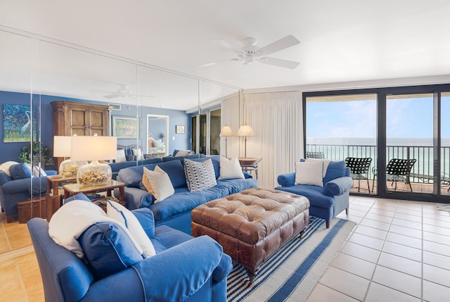 tiled living room featuring ceiling fan and a water view