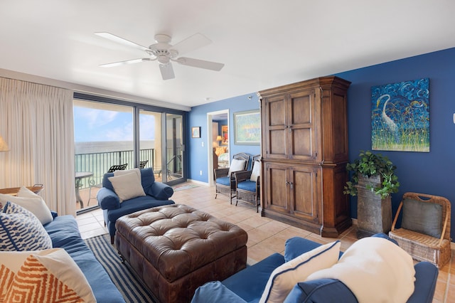 tiled living room featuring ceiling fan and a water view