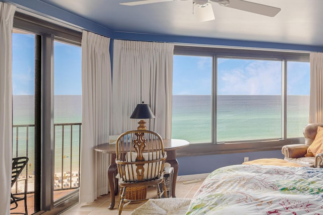 tiled bedroom with ceiling fan and a water view