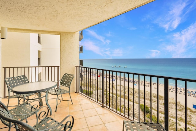 balcony featuring a beach view and a water view