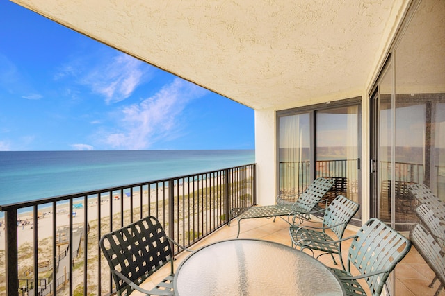 balcony featuring a water view and a beach view