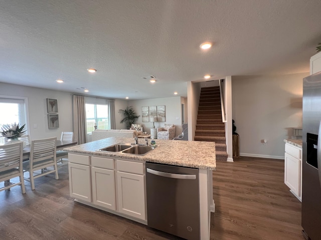 kitchen featuring appliances with stainless steel finishes, a kitchen island with sink, dark wood-type flooring, sink, and white cabinetry