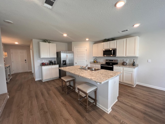 kitchen featuring white cabinets, sink, an island with sink, and appliances with stainless steel finishes