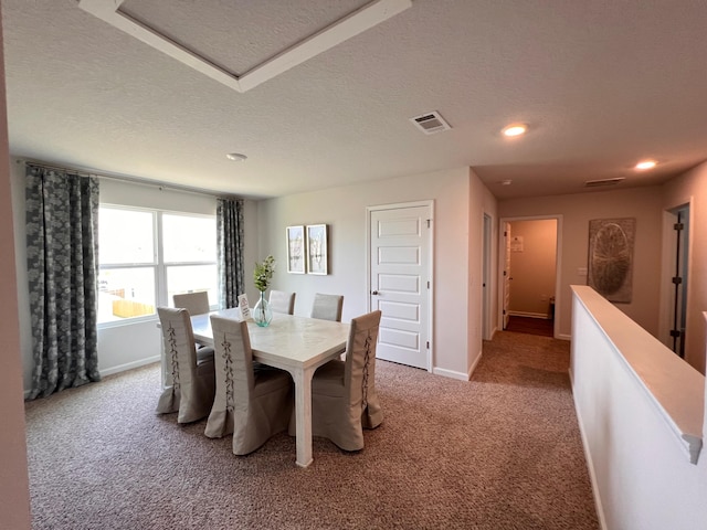 dining area with carpet and a textured ceiling