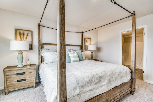 bedroom featuring light carpet and ensuite bath