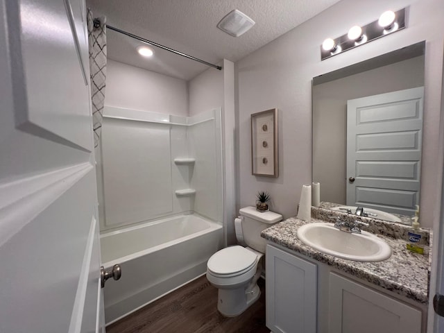 full bathroom featuring a textured ceiling, vanity, shower / bathing tub combination, hardwood / wood-style floors, and toilet