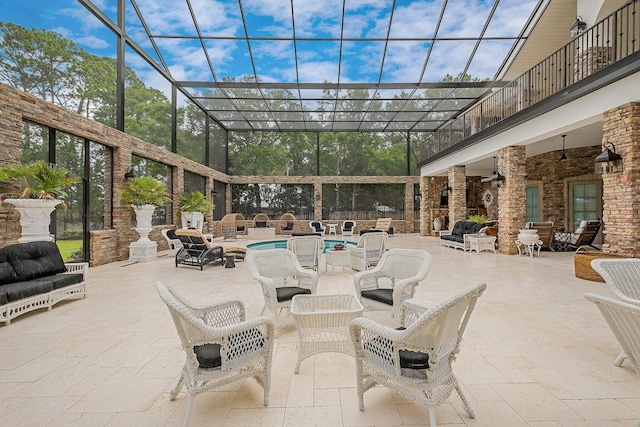 view of patio / terrace featuring an outdoor pool, glass enclosure, ceiling fan, and an outdoor hangout area