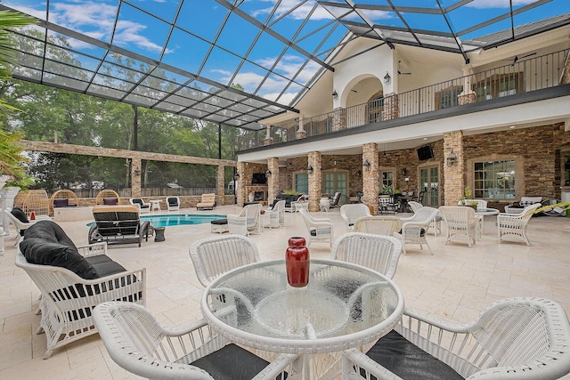 view of patio / terrace featuring outdoor dining area, a lanai, a balcony, and an outdoor pool