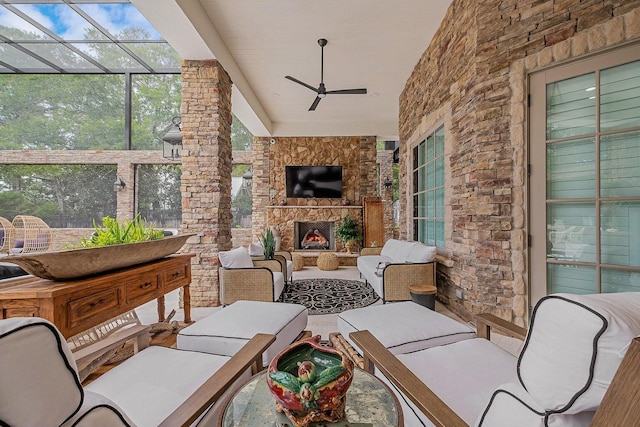 view of patio / terrace featuring glass enclosure, an outdoor living space with a fireplace, and a ceiling fan