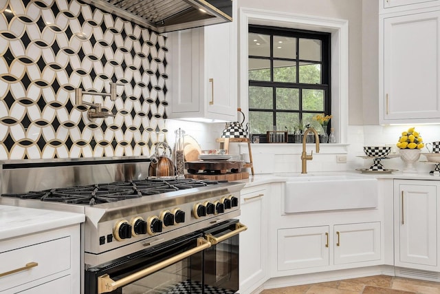 kitchen featuring custom exhaust hood, light countertops, a sink, and stainless steel stove