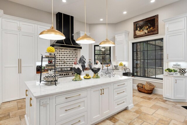 kitchen with recessed lighting, stone tile flooring, white cabinetry, and wall chimney range hood