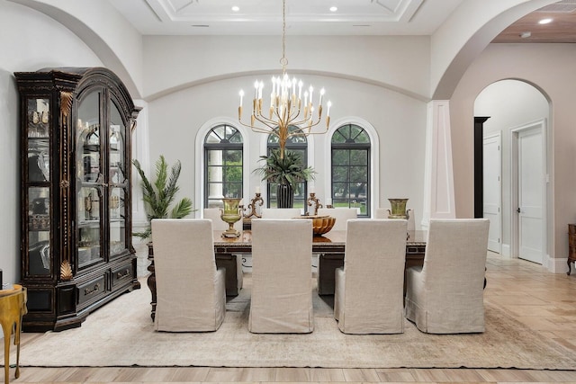 dining room with arched walkways, wood finished floors, a high ceiling, a chandelier, and recessed lighting