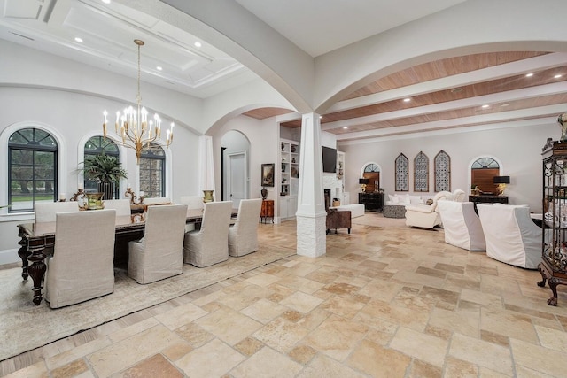 dining space featuring a fireplace, beamed ceiling, stone tile flooring, and recessed lighting